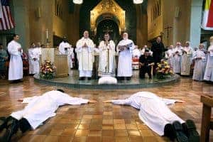 Peter Latouf y Daniel Kim se postran frente al altar durante su ordenación sacerdotal. La Sociedad Maryknoll es doblemente bendecida con dos nuevos sacerdotes