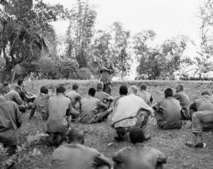 Conduciendo un servicio religioso con un grupo de Marines. (Maryknoll Mission Archives). Autor ve la fe heroica en el sacrificio del capellán militar Maryknoll