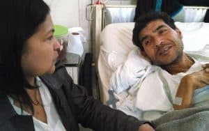 Corazones VIH positivos en Perú: Yolanda Yactayo visita a un paciente con VIH en el hospital. Ella es parte de un grupo de discípulos misioneros laicos que acompañan a personas con VIH. (Cortesía de Joseph Fedora, M.M./Perú)