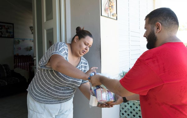 Un voluntario de la parroquia San Miguel Arcángel en Utuado, entrega lleva ayuda al hogar de una familia afectada por el Huracán Maria. (Octavio Durán OFM/Puerto Rico)