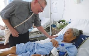 El Padre Maryknoll Jack Northrop visita a los enfermos en el Hospital Nacional Zacamil en San Salvador, El Salvador.