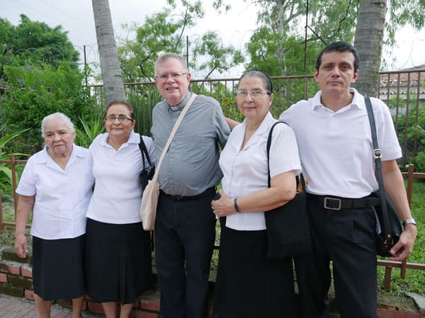 Miembros del ministerio para los enfermos de la parroquia Cristo Salvador y el padre Northrop brindan consuelo espiritual a enfermos en El Salvador.