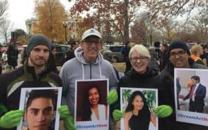 Miembros de la Oficina de Asuntos Globales marchan sosteniendo fotos de inmigrantes con Estatus de Protección Temporal (TPS, por sus siglas en inglés). MOGC también se solidariza con Haití, El Salvador y África, y llama a políticos y personas de fe a que denuncien el racismo y las políticas anti-inmigrantes. (Imagen cortesía de la Oficina de Asuntos Globales Maryknoll.)