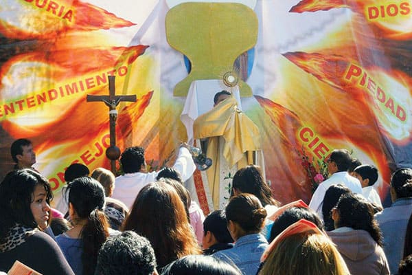 El Padre Enrique Bustamante alza al Santísimo durante la celebración de Corpus Christi en la parroquia San Pío X en Cochabamba, Bolivia