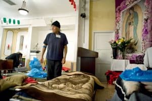 Un inmigrante indocumentado de México tiende su cama para pasar la noche en el altar de la parroquia Misión Dolores en el 2014. (CNS/Los Ángeles)