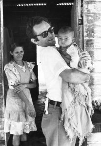 Llamados, enviados, transformados: 100 años de Envío a Misión - El Hermano Maryknoll John Blazo carga un bebé en Guatemala, donde sirvió como misionero en los 1970s. (Maryknoll Mission Archives/Guatemala)