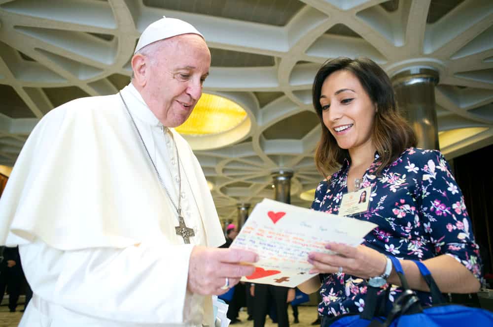 Yadira Vieyra, una de las 34 auditores jóvenes durante el sínodo, le entrega al Papa Francisco una carta escrita por niños. (CNS/Ciudad del Vaticano)