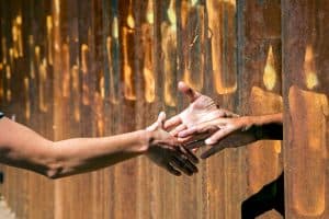 USCCB Unas manos se encuentran en la frontera durante una marcha en Nogales, Arizona, y Nogales en Sonora, México. (CNS/México)