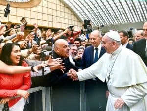 El Padre Maryknoll Roberto Rodriguez saluda al Papa Francisco en Roma, después de avisarle que el Padre jesuita Jon Sobrino estaba presente. (L’Osservatore Romano/Vaticano)
