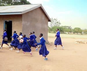 Estudiantes en tanzania: Niñas de la Escuela Primaria Mmazami, en Tanzania, corren después de clases. Muchos estudiantes están en la escuela debido al apoyo de la Hermana Maryknoll Marion Hughes. (Sean Sprague/Tanzania)