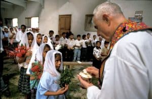 Sacerdote de los Maya El Padre Bill Mullan celebra la Primera Comunión de niños en la aldea de Cahabael, Petén, Guatemala, en el 2001. (Sean Sprague/Guatemala)