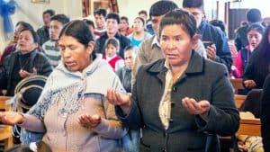 Residentes del centro poblado de Jayllihuaya, en Puno, Perú, y visitantes rezan el Padre Nuestro en la lengua aymara durante la misa de Todos los Santos. (Nile Sprague/Perú)