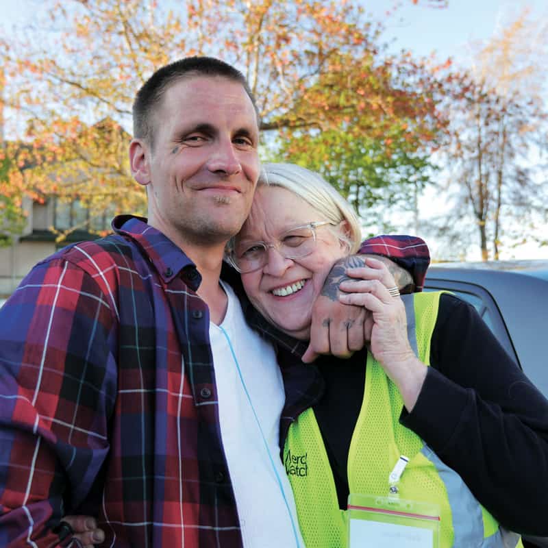 Mike, un hombre sin hogar en Everett, Washington, abraza a Gail Pyper, una voluntaria de MercyWatch, una caridad católica que ofrece ayuda a quienes viven en las calles. (Fotos por Peter Saunders/Washington)