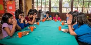 Niñas abusadas: A la hora del almuerzo en el refugio Hogar Nuestra Casa en Cochabamba, las niñas, acompañadas del personal, hacen la bendición antes de comer. (Nile Sprague/Bolivia)