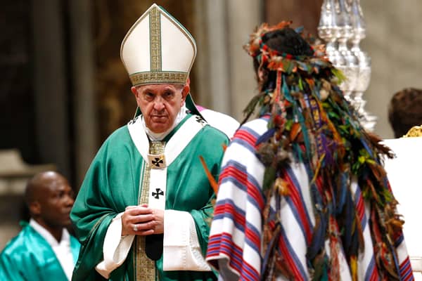 Sínodo Amazónico- El Papa Francisco acepta obsequios de un hombre indígena durante la misa final del Sínodo de la Amazonía. (CNS / Paul Haring / Roma)