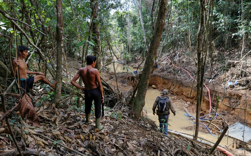 Un grupo de yanomami aparece en esta foto de archivo con miembros de una agencia ambiental de Brasil durante una operación contra la minería ilegal de oro en tierras indígenas en el corazón de la selva amazónica. (Foto CNS-Bruno Kelly, Reuters)