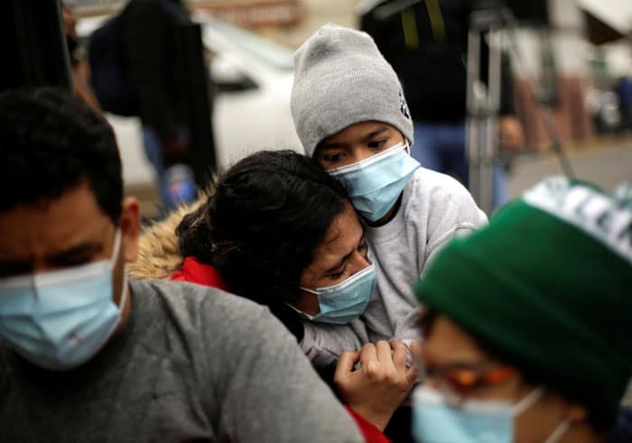 asilo esperanza: A Venezuelan migrant cries as she hugs her son near the Paso del Norte International Bridge in Ciudad Juarez, Mexico, Jan. 21, 2021, after requesting asylum in the U.S. Asylum-seekers along the border are expressing hope with U.S. President Joe Biden now in office. (CNS photo/Jose Luis Gonzalez, Reuters)