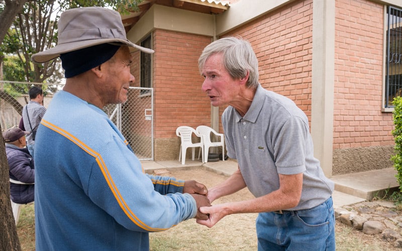 Misionero O’Donoghue saluda a Andrés, un paciente con problemas mentales en el jardín del hogar de las Hermanas de la Caridad en la ciudad de Cochabamba, Bolivia. (NIle Sprague/Bolivia)