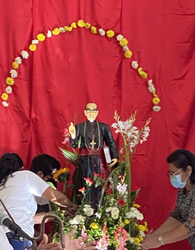 Los feligreses de la iglesia de San Antonio de Padua en Soyapango, El Salvador, colocan flores alrededor de la estatua de San Oscar Romero en su fiesta, el 24 de marzo de 2021. (Foto del CNS / Rhina Guidos)