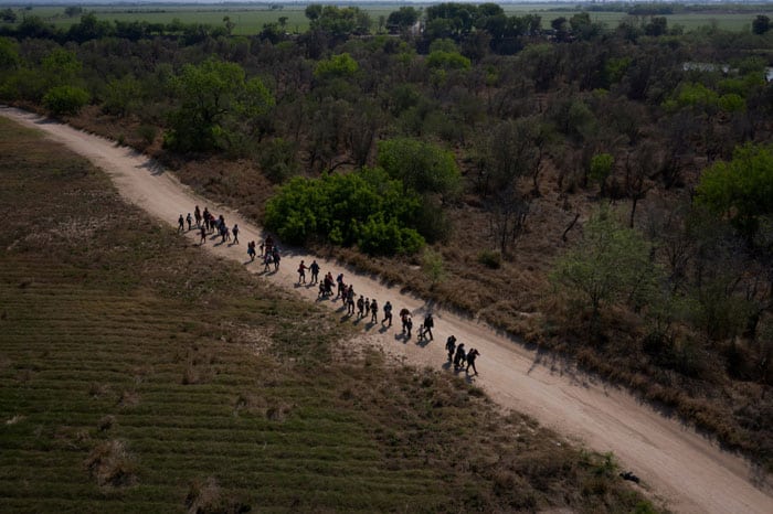 En la frontera: Migrantes de Centroamérica caminan hacia el muro fronterizo entre Estados Unidos y México en Peñitas, Texas, el 26 de marzo de 2021, después de cruzar el Río Grande. (Foto del CNS / Adrees Latif, Reuters)