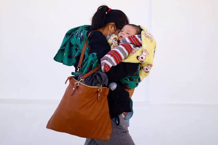 En la frontera: Una migrante de Guatemala que buscaba asilo en los Estados Unidos y fue deportada camina con su bebé en Ciudad Juárez, México, el 27 de marzo de 2021. (Foto de CNS / Edgard Garrido, Reuters)