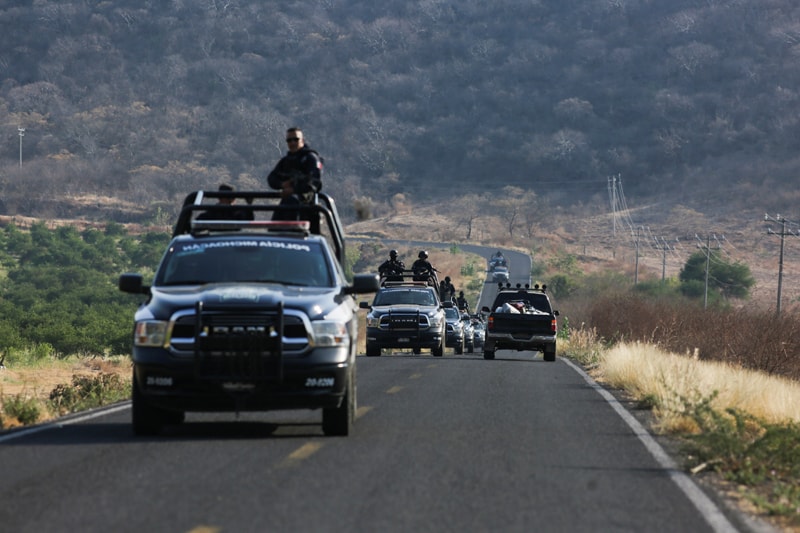 Un convoy de la policía estatal patrulla una carretera cerca de Aguililla, México, el 23 de abril de 2021, luego de la visita del arzobispo Franco Coppola, nuncio apostólico en México. Los carteles de la droga se han enfrentado entre sí y han bloqueado las carreteras de la ciudad, lo que ha dejado a los residentes sin poder viajar libremente y provocando escasez de todo, desde alimentos hasta combustible. (Foto del CNS / Alan Ortega, Reuters)