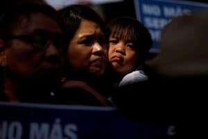 Un niño abraza a una mujer en Los Ángeles durante una protesta contra una orden ejecutiva del expresidente Donald Trump que separó a niños que cruzaron la frontera sur de familias el 7 de junio de 2018. (Foto CNS/Patrick T. Fallon, Reuters)