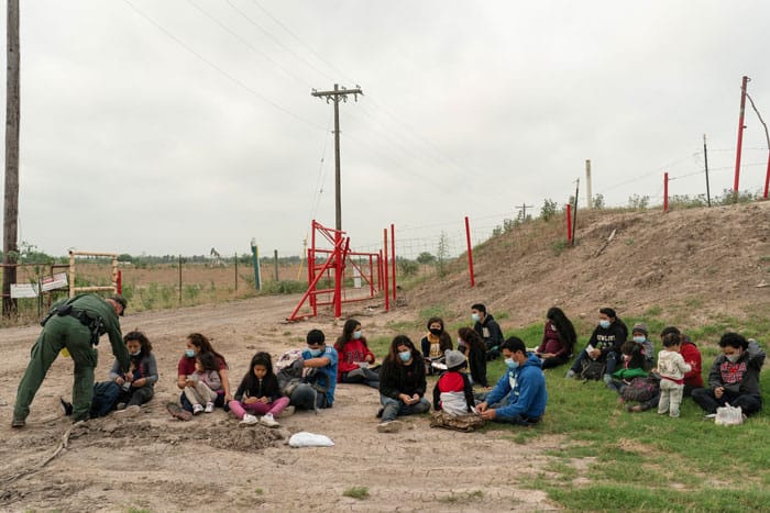 Familias migrantes solicitantes de asilo en La Joya, Texas, esperan ser transportadas por la Patrulla Fronteriza después de cruzar el Río Bravo desde México el 27 de abril de 2021. (Foto de CNS / Go Nakamura, Reuters)