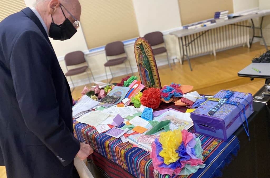 Cerca de una mesa con oraciones escritas por niños, obispos abordan inmigración