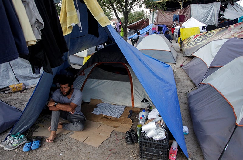 Un migrante en busca de asilo se sienta dentro de una carpa en una plaza pública en Reynosa, México, donde cientos de migrantes se están refugiando, el 9 de junio de 2021. El Papa Francisco ha escrito una carta al obispo Eugenio Lira Rugarcía de Matamoros condenando la violencia reciente de los carteles de la droga en la ciudad fronteriza. (Foto del CNS / Daniel Becerril, Reuters)