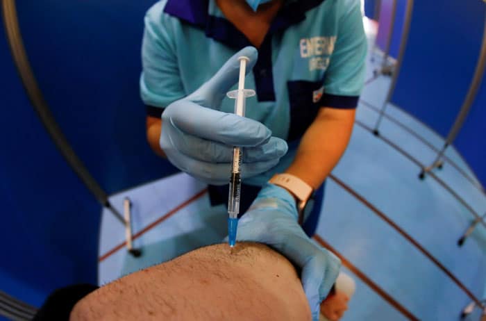 A health care worker administers the second dose of the Pfizer BioNTech COVID-19 vaccine to a man at a vaccination center in Ronda, Spain, June 30, 2021. (CNS photo/Jon Nazca , Reuters)