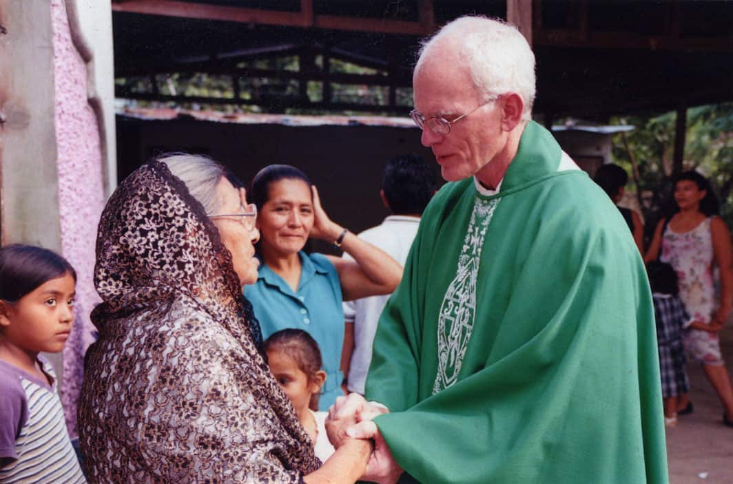 Como sacerdote Maryknoll en El Salvador en 2004, el Padre James Lynch saludó a sus feligreses después de la misa dominical (Bernice Kita/El Salvador)