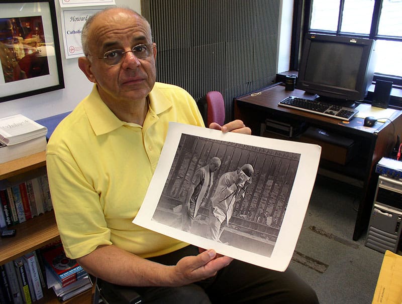 9-11:En esta imagen de archivo, el Padre Maryknoll Raymond Nobiletti sostiene una foto tomada por Gulnara Samoilova el 11 de septiembre del 2001 después de que se derrumbó la torre sur del WTC, cubriendo al sacerdote, que estaba atendiendo a las víctimas de quemaduras, y a todos los que estaban cerca en una nube oscura de cenizas. (Schwartz / Estados Unidos)