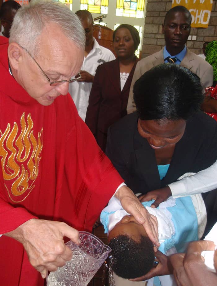 Domingo de Pentecostés de 2010, cuando el padre Nadeau bautiza a los niños en la Iglesia Cristo Maestro, de la Universidad Kenyatta en Nairobi, Kenya. (Archivos de la Misión Maryknoll)