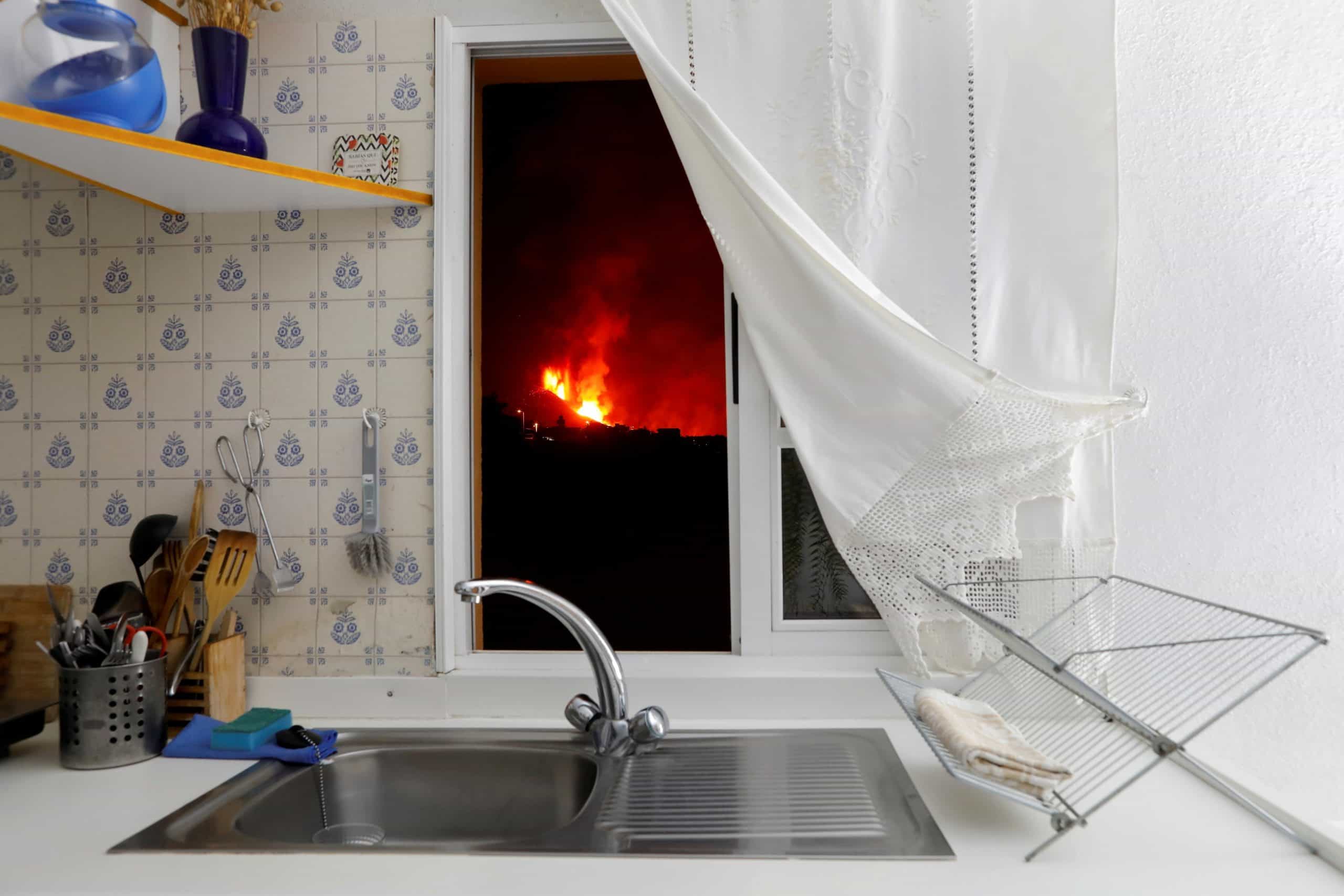 movimiento laudato si: La lava se ve a través de la ventana de una cocina en El Paso, España, el 28 de septiembre de 2021, durante una erupción volcánica en La Palma en las Islas Canarias de España. (Foto de CNS / Jon Nazca, Reuters)