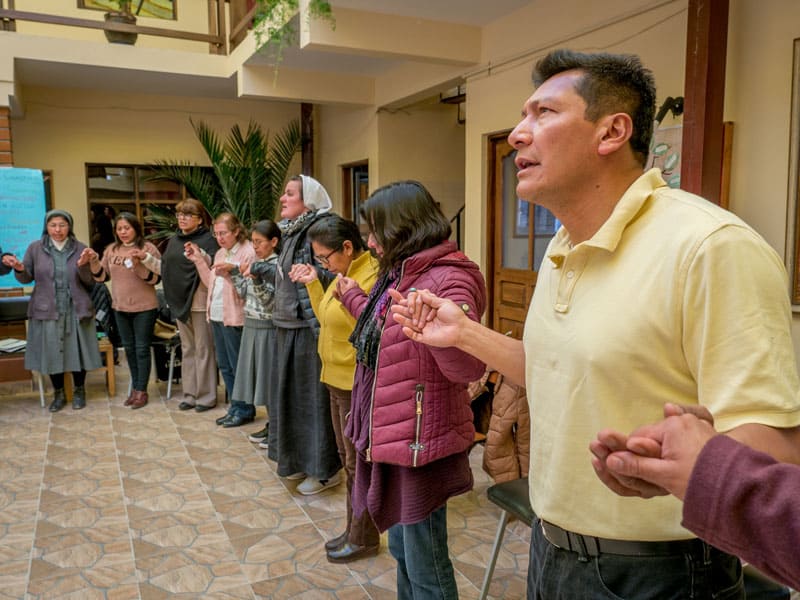 Participantes unen sus manos en una oración como parte de un taller ESPERE sobre perdón y reconciliación en una casa parroquial jesuita en Oruru, Bolivia. (Nile Sprague/Bolivia)