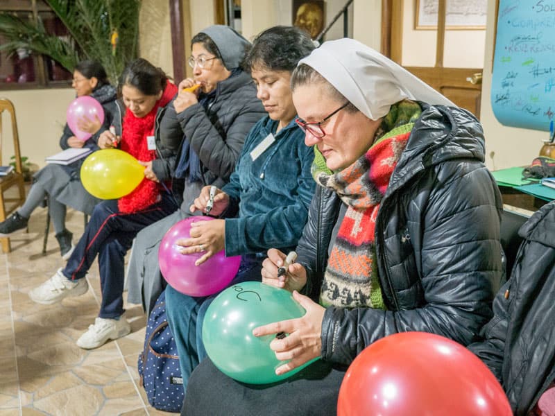 Durante un taller de ESPERE en Oruru, los participantes inflan globos y escriben tres cosas sobre sí mismos. Luego se les pide que reboten los globos y los mantengan a flote, como una forma de practicar el cuidado de su propia vida y la de los demás. (Nile Sprague/Bolivia)