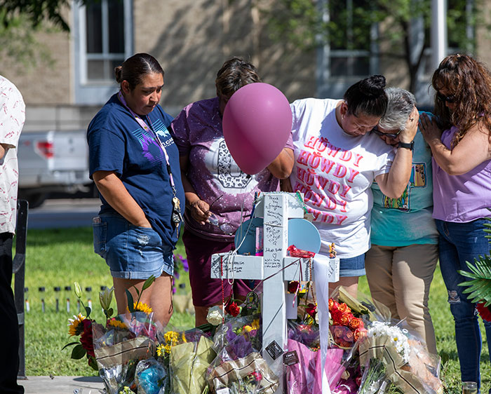 Familias afligidas y miembros de la comunidad se reúnen en un lugar conmemorativo en el centro de Uvalde, Texas, donde las cruces y los obsequios rinden homenaje a los 19 estudiantes y dos maestras asesinados en un tiroteo masivo en la escuela primaria Robb. (Octavio Durán/EE.UU.)