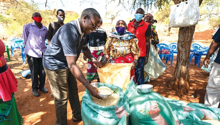 Dominic Mutunga, quien conectó al Padre Lance Nadeau con las necesidades extremas de las personas en Kibwezi, ayuda a distribuir alimentos en la estación Dunguni de San Juan Bautista. (Gregg Brekke/Kenya)