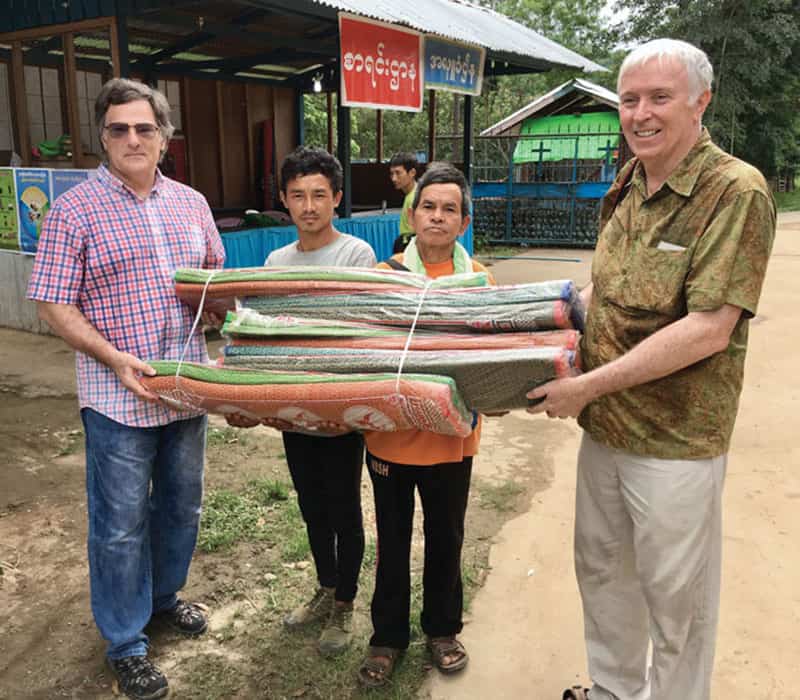 En un viaje de ayuda periódica a Myanmar, el hermano Raible y el voluntario Jim Mulqueen (derecha) van a distribuir colchonetas de dormir a los desplazados internos. (John Beeching/Myanmar)