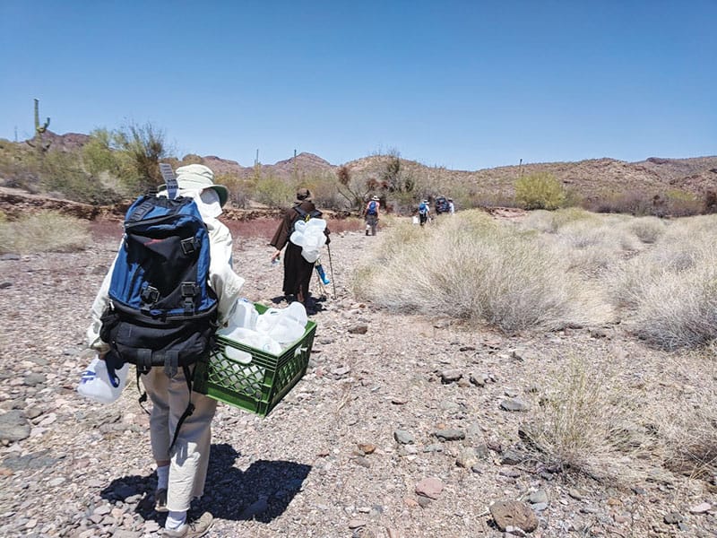Miembros de Tucson Samaritans, una organización de ayuda humanitaria, reponen jarras de agua a lo largo de los senderos de migrantes en el desierto de Sonora/Arizona. (CNS/Peter Tran, Global Sisters Report)