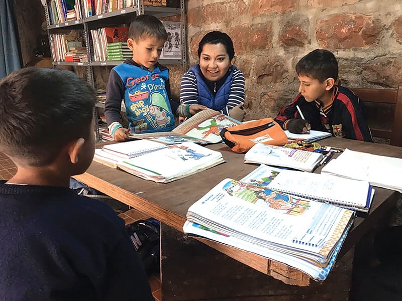 Martínez es fotografiada hablando con niños bolivianos durante una visita al programa de tutoría que dirige la Misionera Laica Maryknoll Phuong Minh Nguyen en Tacopaya. (Cortesía de Silvana Martínez/Bolivia)