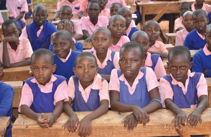 Los estudiantes comparten escritorios en la escuela primaria Mukononi, de Kibwezi, gravemen- te afectada por el cambio climático, donde el hambre puede impedir que los niños aprendan. (Moses Njagua Gitahi/Kenia)