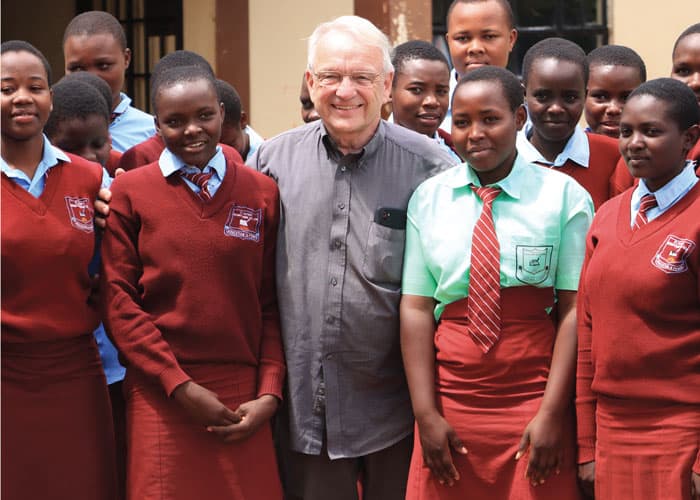 El Superior General Maryknoll, Padre Lance Nadeau, ayuda a estudiantes a plantar árboles en la Escuela Malembwa, Kenia, donde Maryknoll ayuda a los sobrevivientes del cambio climático. (Moses Njagua Gitahi/Kenia)