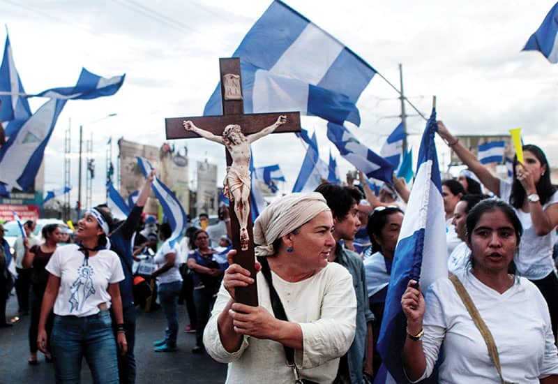 Una manifestante sostiene un crucifijo durante una protesta contra el gobierno del presidente nicaragüense Daniel Ortega en Managua el 15 de mayo del 2018. (CNS, Oswaldo Rivas/Nicaragua)
