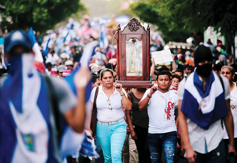 Una mujer y un hombre cargan una estatua de María en una marcha en apoyo de la Iglesia Católica en Managua, Nicaragua. El gobierno acusa a los obispos de alentar las protestas. (CNS, Oswaldo Rivas/Nicaragua)