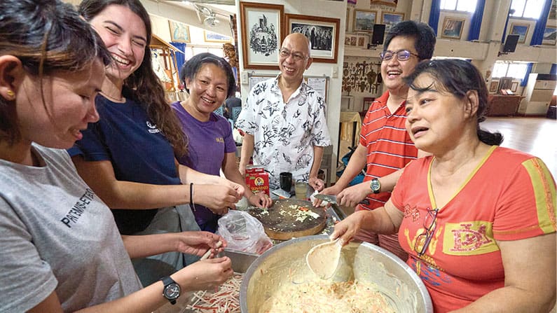 El misionero Maryknoll Joyalito Tajonera (centro) y voluntarios de varias nacionalidades preparan comida en el refugio para migrantes Ugnayan en Taichung, Taiwán. (Paul Jeffrey/Taiwan)