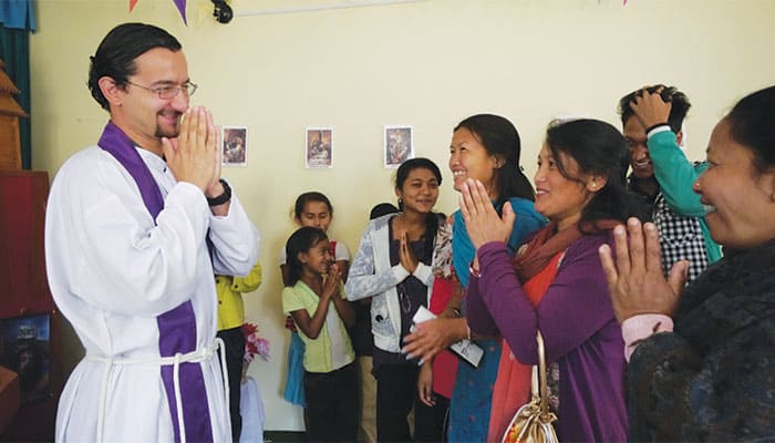 En Nepal, el misionero comparte un alegre momento de encuentro con feligreses y miembros de la comunidad. (Sean Sprague/Nepal)