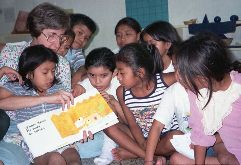 Durante su servicio misionero en Guatemala en el 2000, la Hermana Maryknoll Trant les lee un libro a niños. (Sean Sprague/Guatemala)