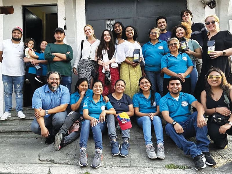 Afiliados Maryknoll en polos azules reciben a estudiantes y personal de Maryknoll, incluyendo a Ray Almanza y a Luna Stephanie (fila inferior, extremos izq. y dcho.) en Caminando por la Paz. (Cortesía de Luna Stephanie/Guatemala)